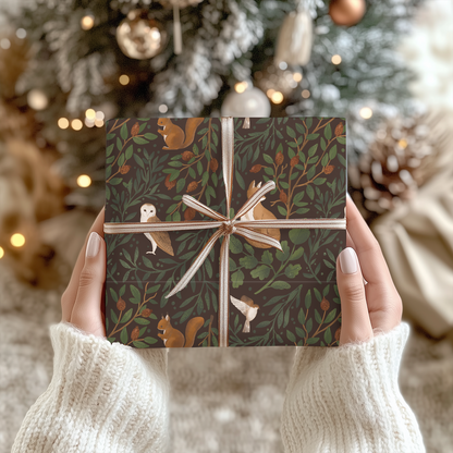 a person holding up a present in front of a christmas tree