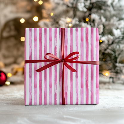 a pink and white striped gift box with a red ribbon