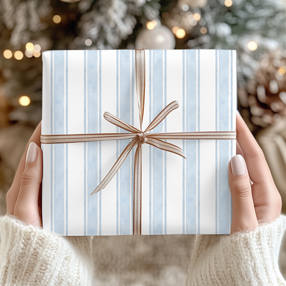 a person holding a wrapped present in front of a christmas tree