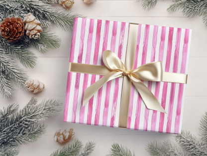 a present wrapped in pink and white paper with a gold bow