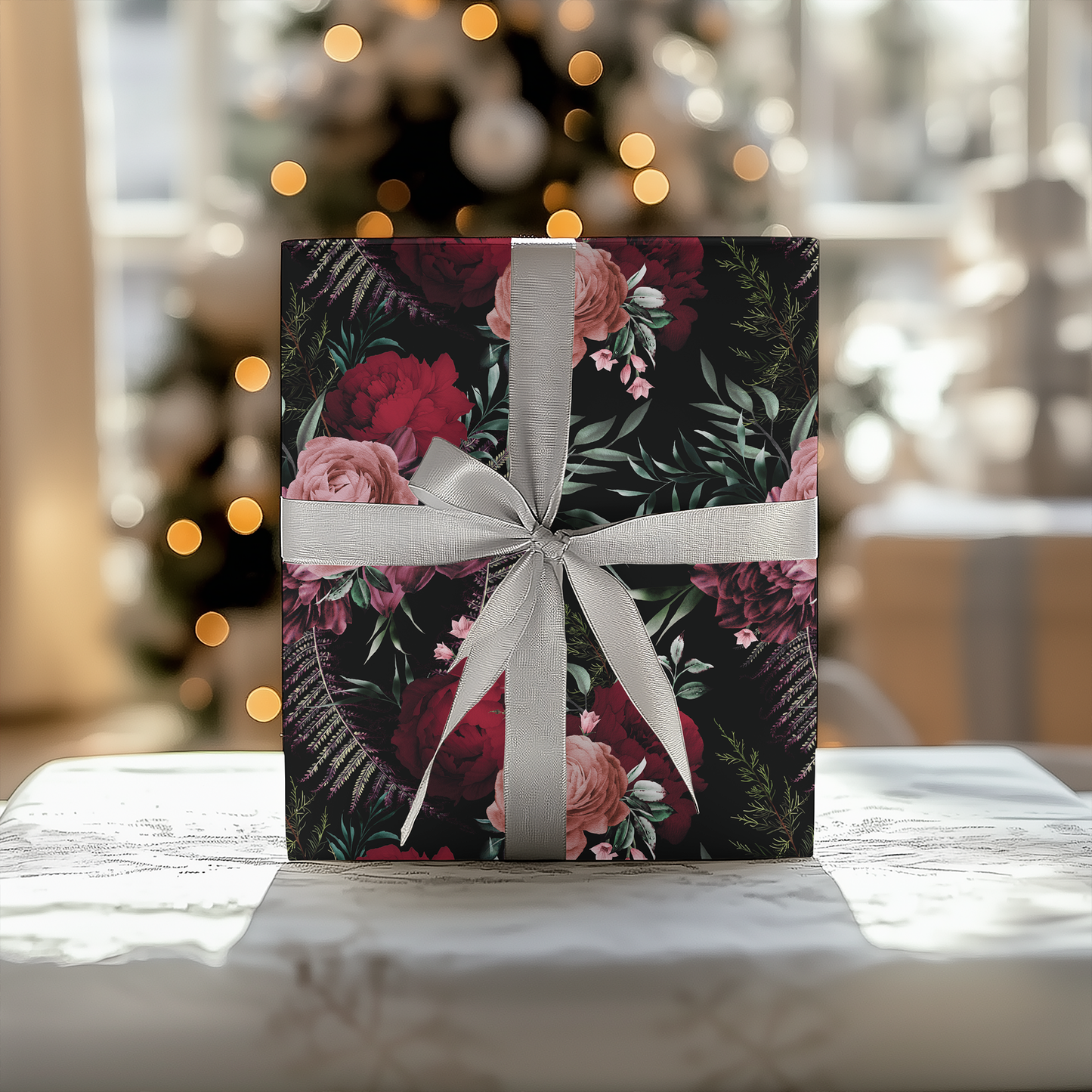 a gift box with a white ribbon on a table in front of a christmas tree