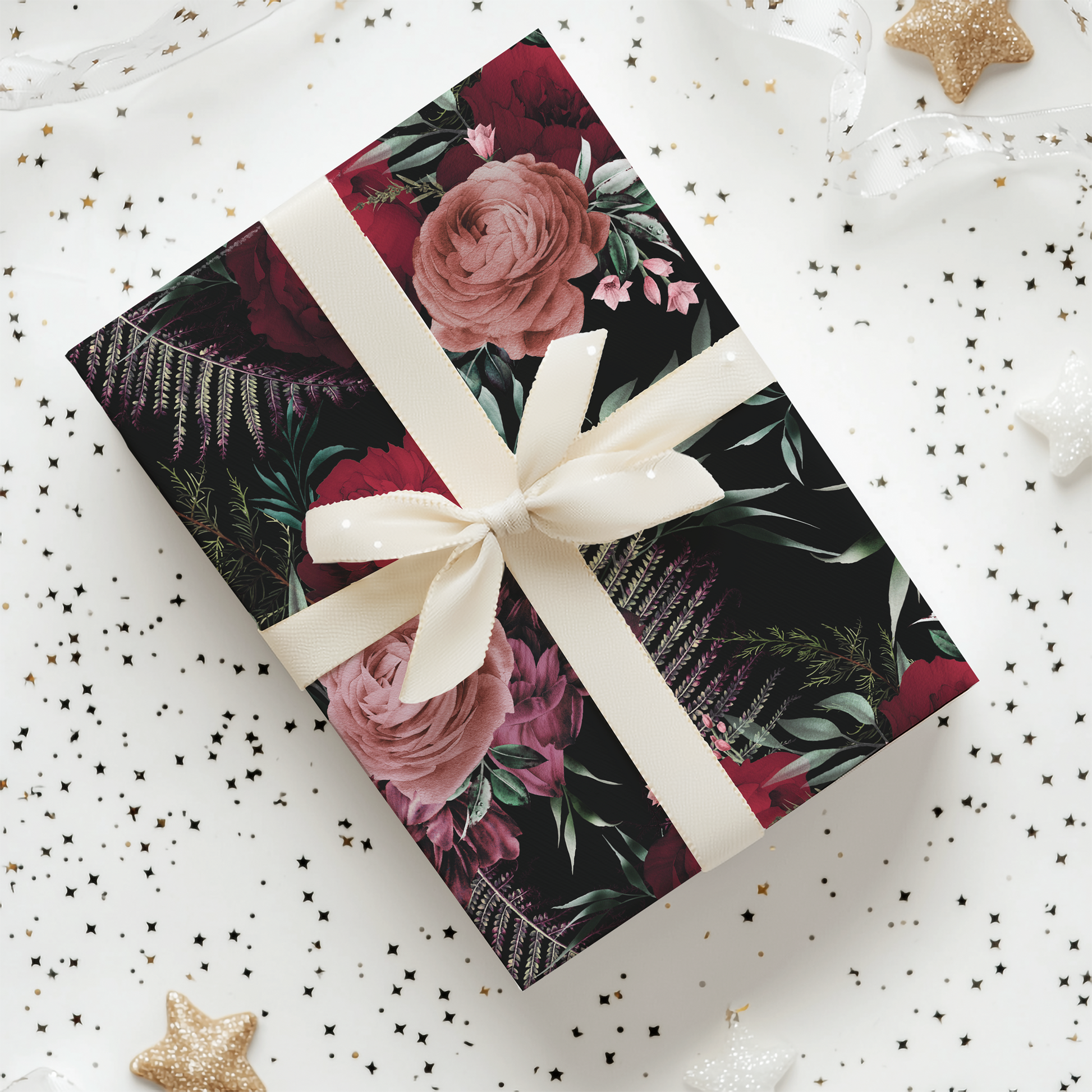 a gift wrapped in a floral wrapping paper with a white ribbon