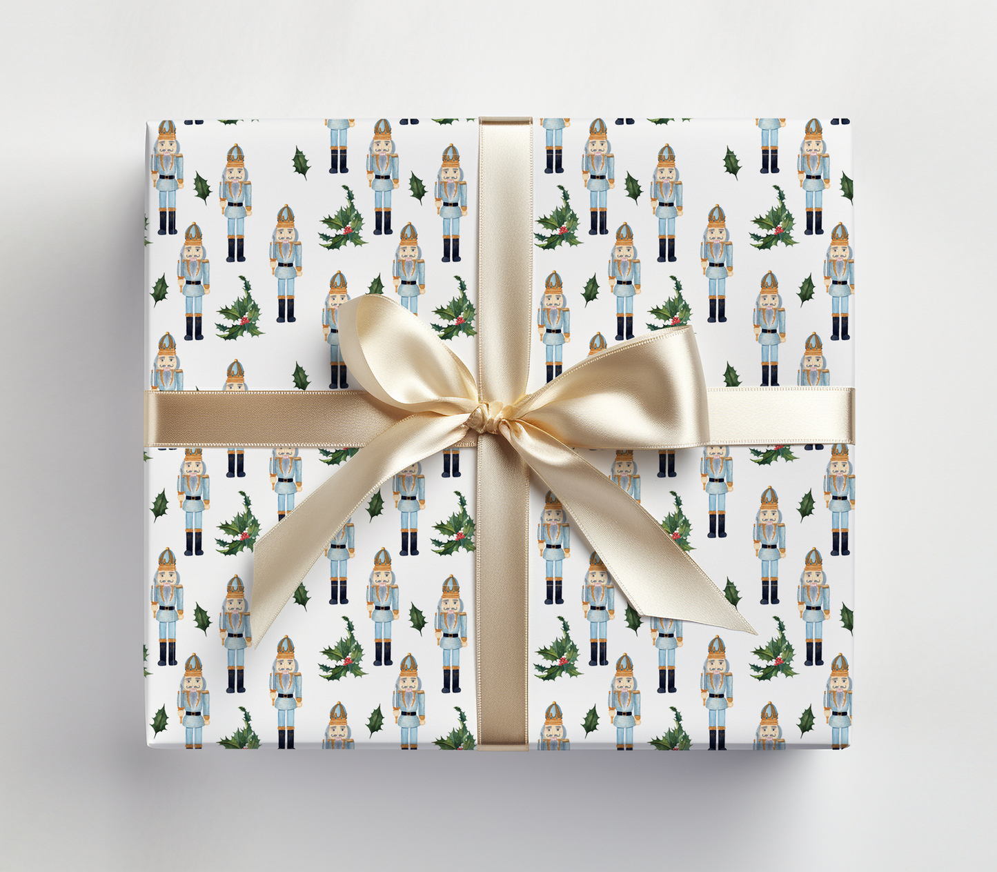 a present wrapped in a white wrapping paper with a gold ribbon