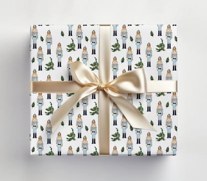 a present wrapped in a white wrapping paper with a gold ribbon