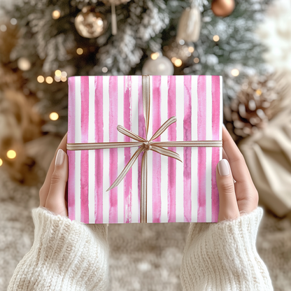 a person holding a pink and white striped present