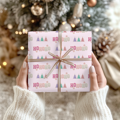 a person holding a wrapped present in front of a christmas tree