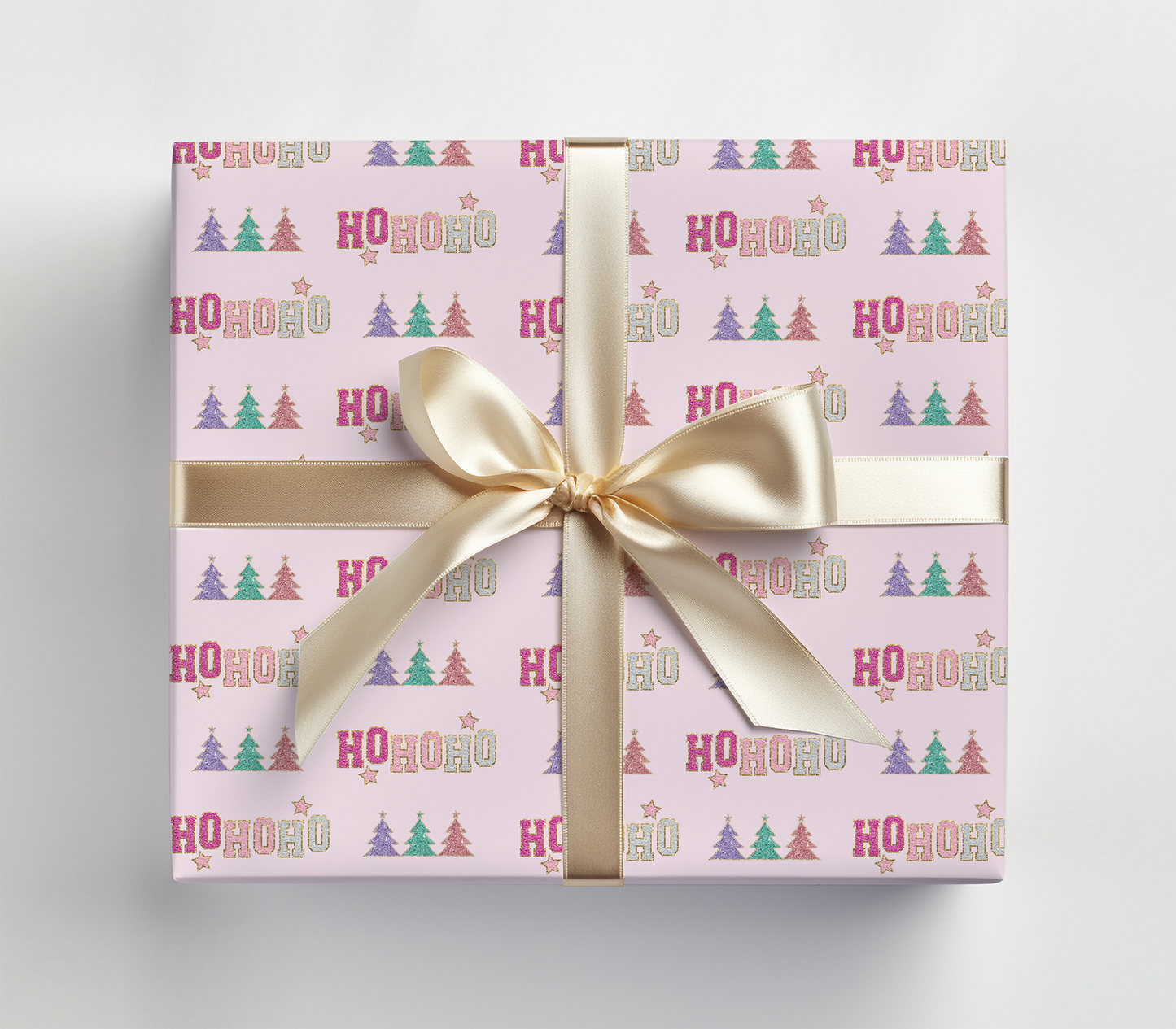 a pink gift box with a gold ribbon and a bow