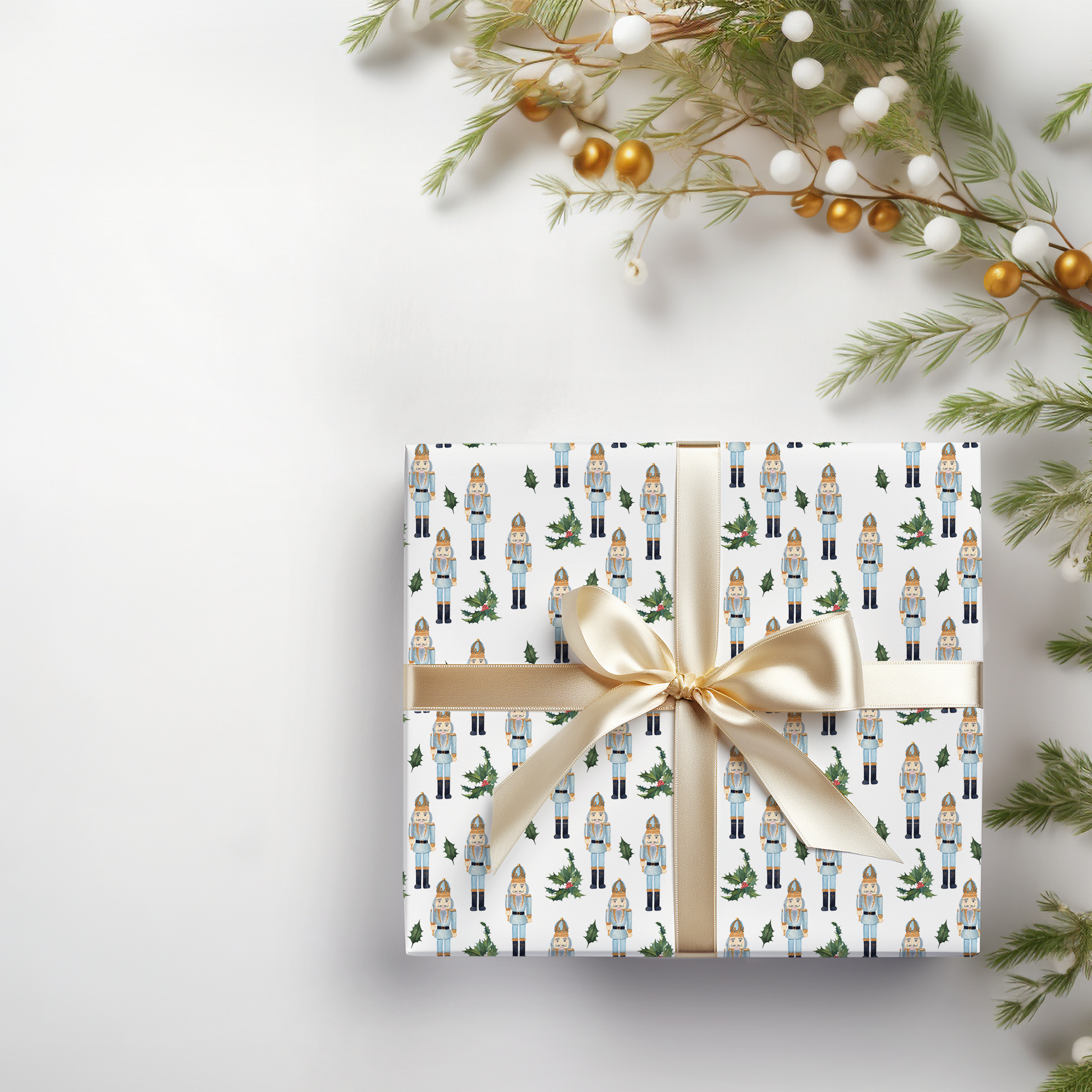 a present wrapped in white paper with a gold bow