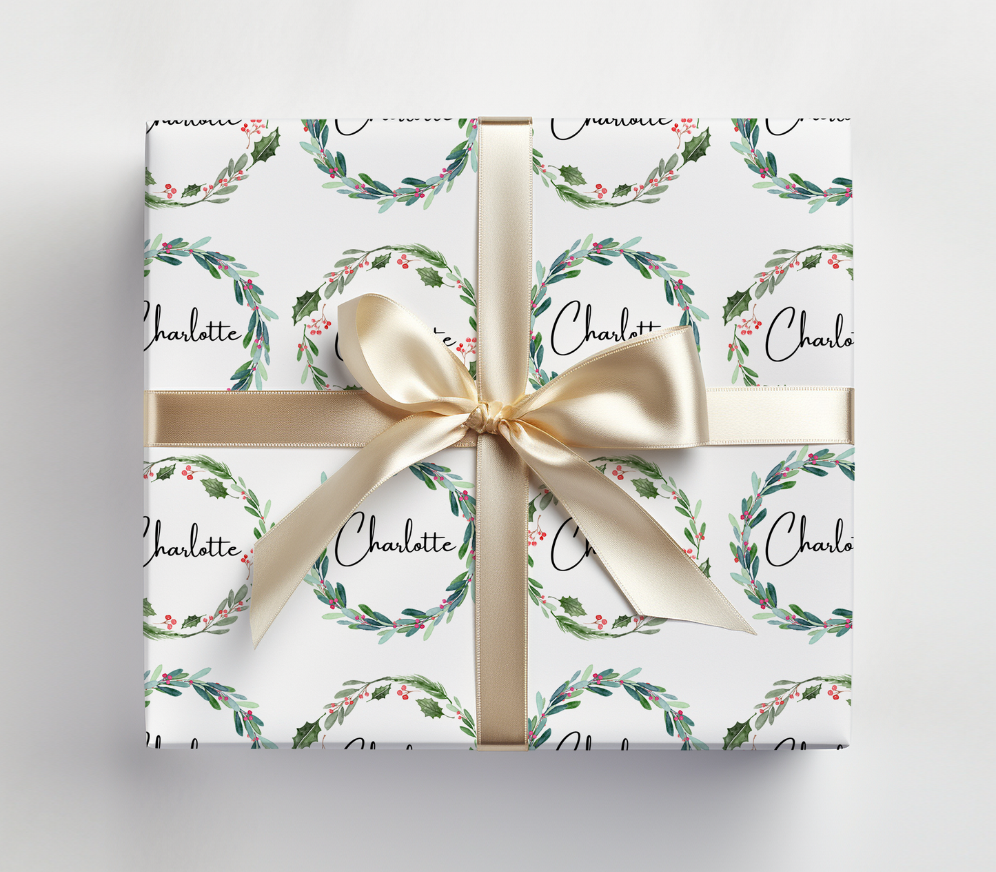 a gift wrapped in a white wrapping paper with a gold bow