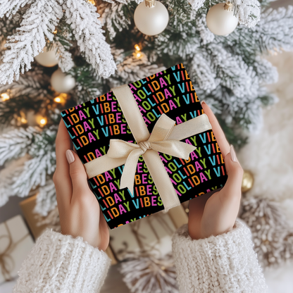 a person holding a present in front of a christmas tree
