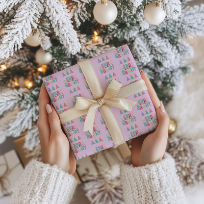 a person holding a wrapped present in front of a christmas tree