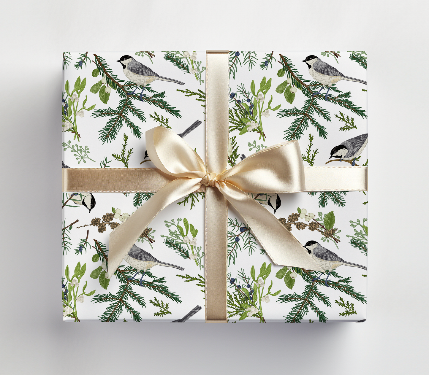 a gift wrapped in a white wrapping paper with a gold ribbon