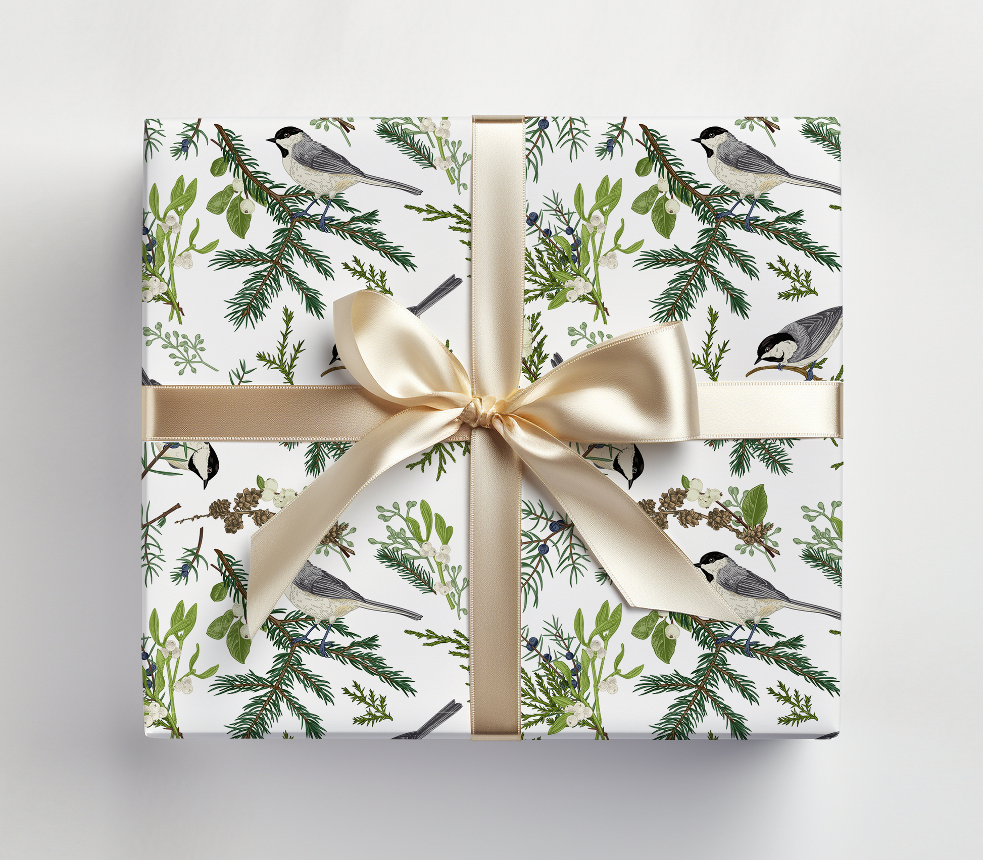 a gift wrapped in a white wrapping paper with a gold ribbon